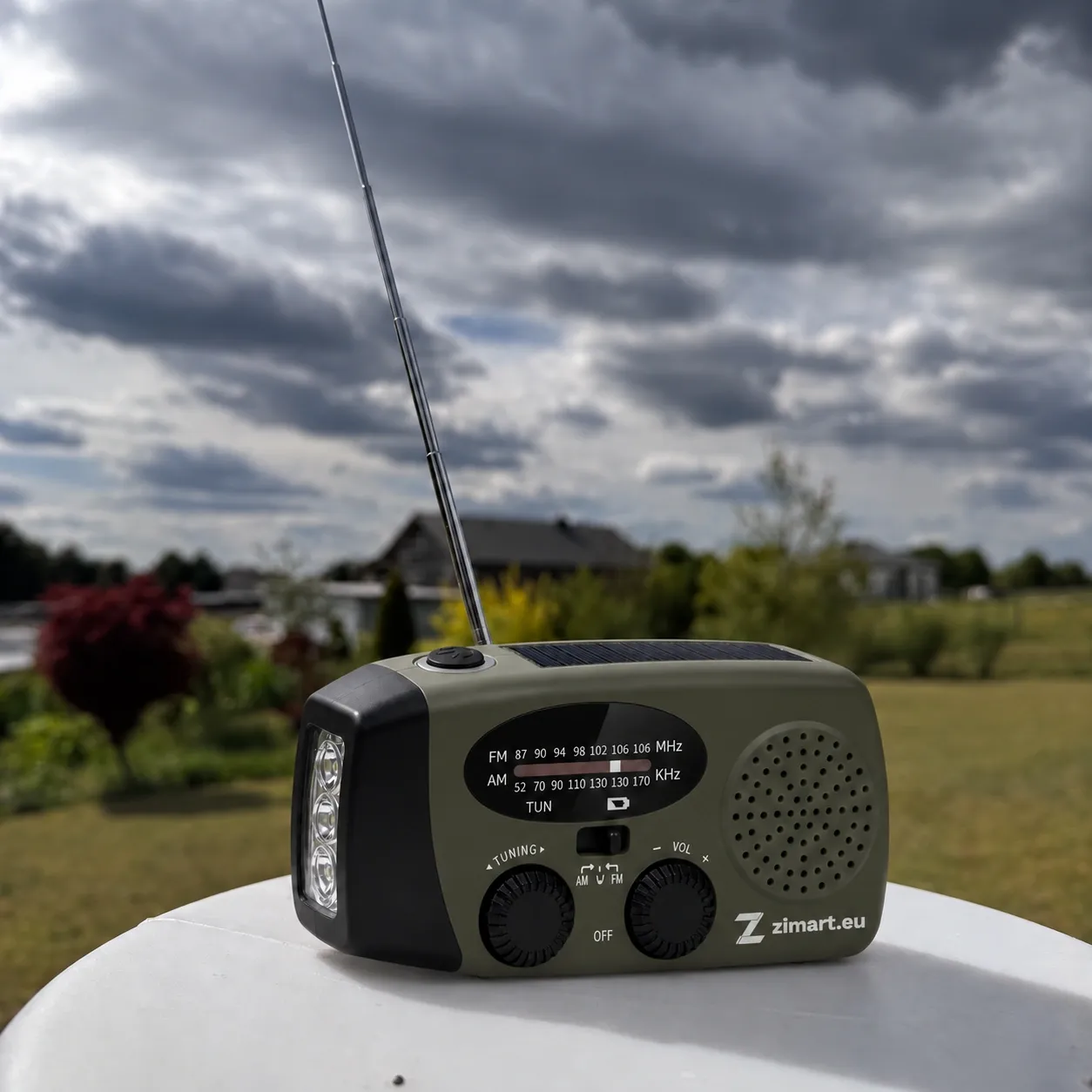 ZIMART Notfallradio auf einem Tisch im Freien unter bewölktem Himmel